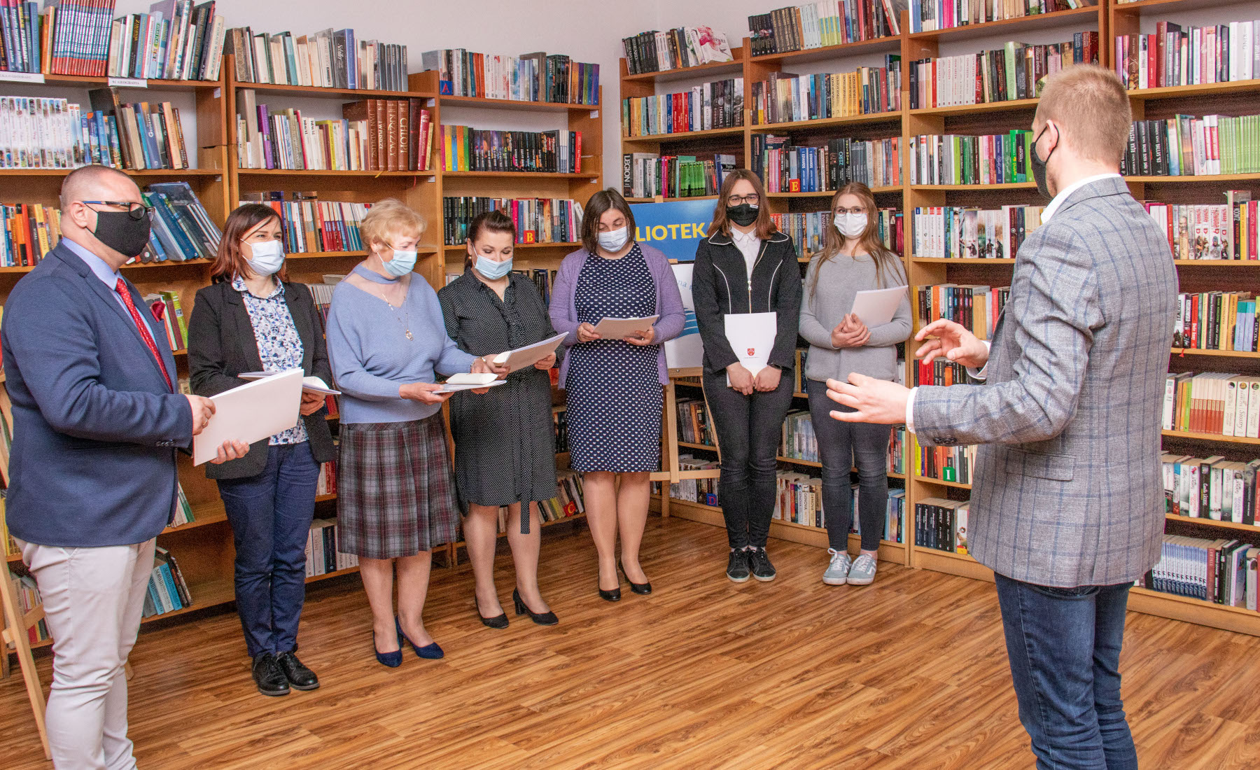 Bibliotekarze ustawieni w rzędzie podczas odbierania listów z życzeniami